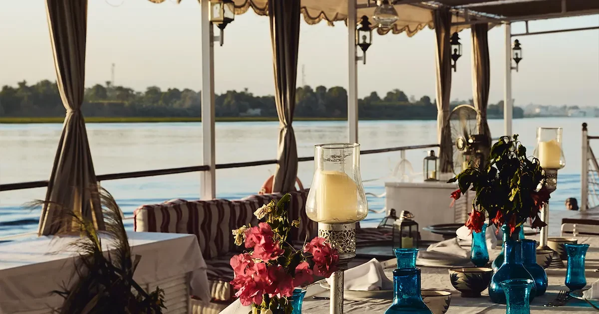 The traditional, elegant Lotus Dahabiya sailing at sunset on the Nile.