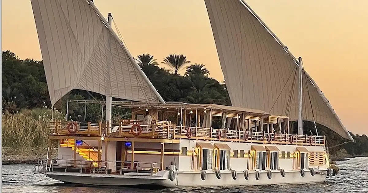 Guests sipping drinks on the shaded sun deck of the Altesse Dahabiya at sunset.