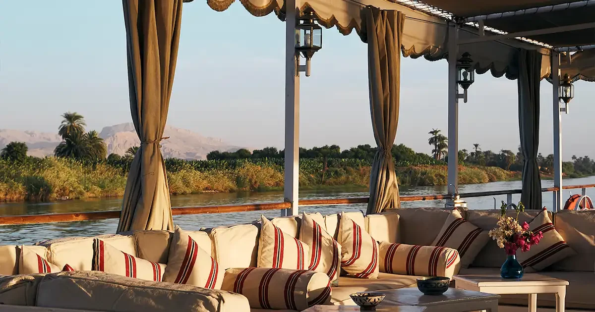 The traditional, elegant Lotus Dahabiya sailing at sunset on the Nile.